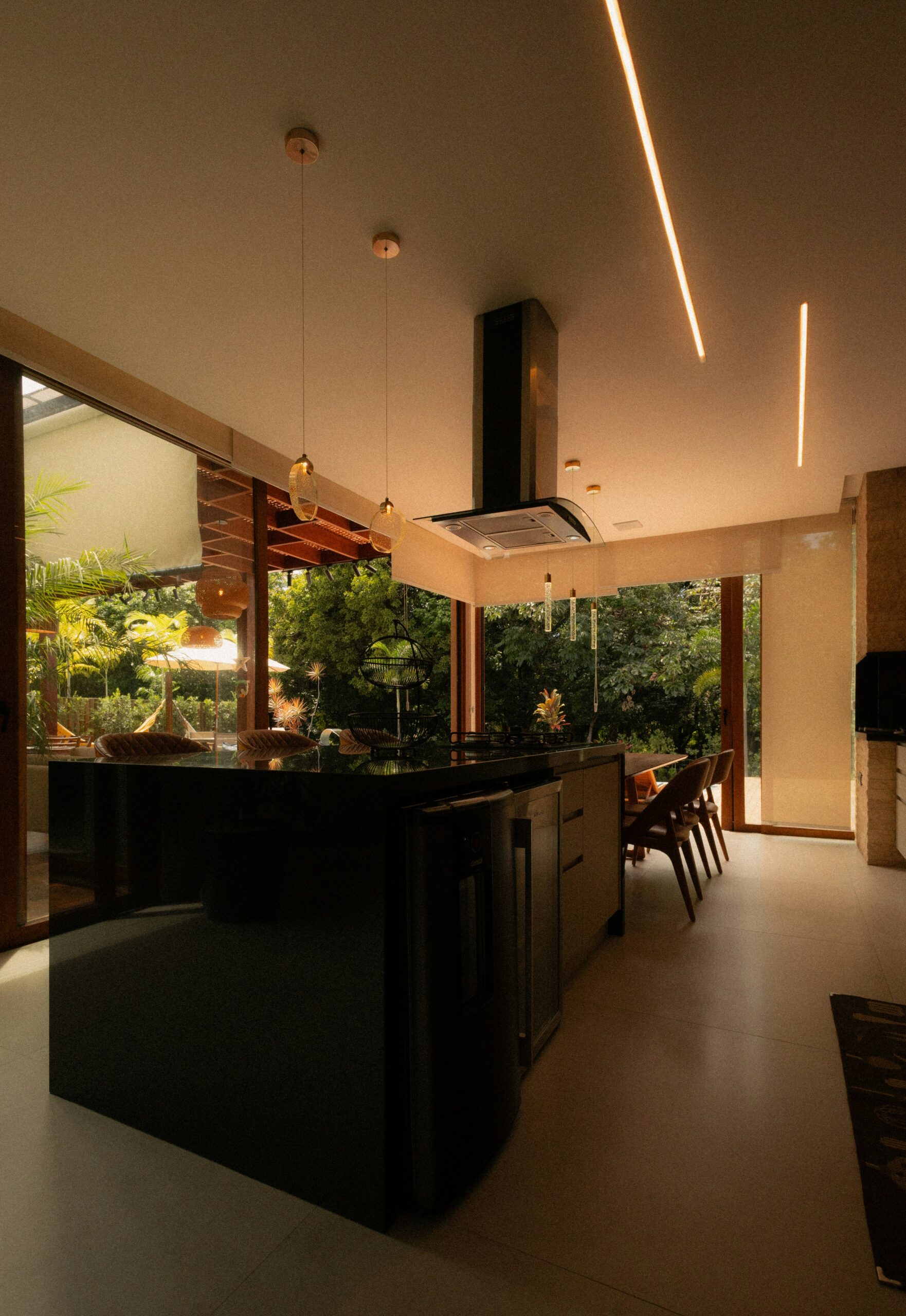 Modern kitchen island with pendant lights and direct view of greenery outside