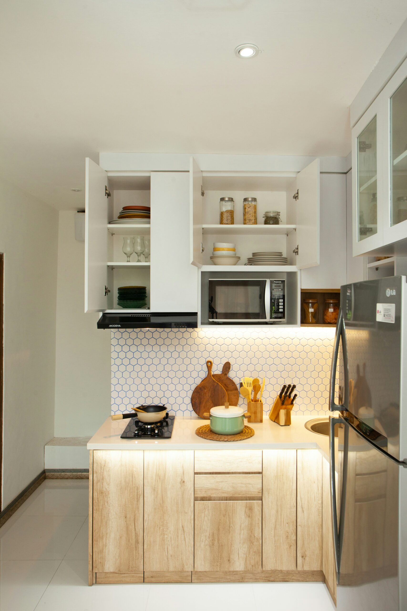 A kitchen with a refrigerator, stove, microwave, and cabinets